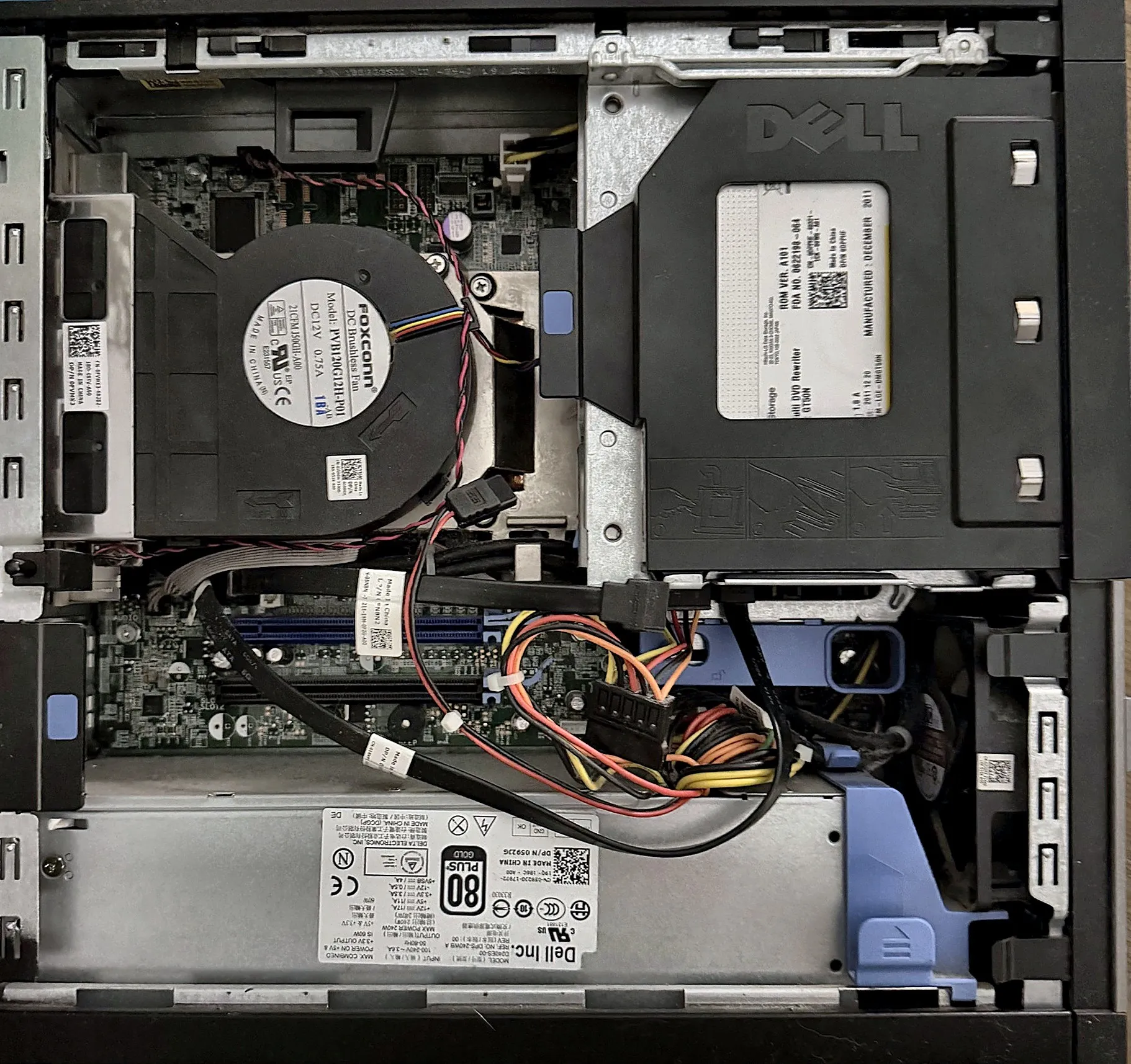 A pulled office desktop opened up on a workbench mid-teardown