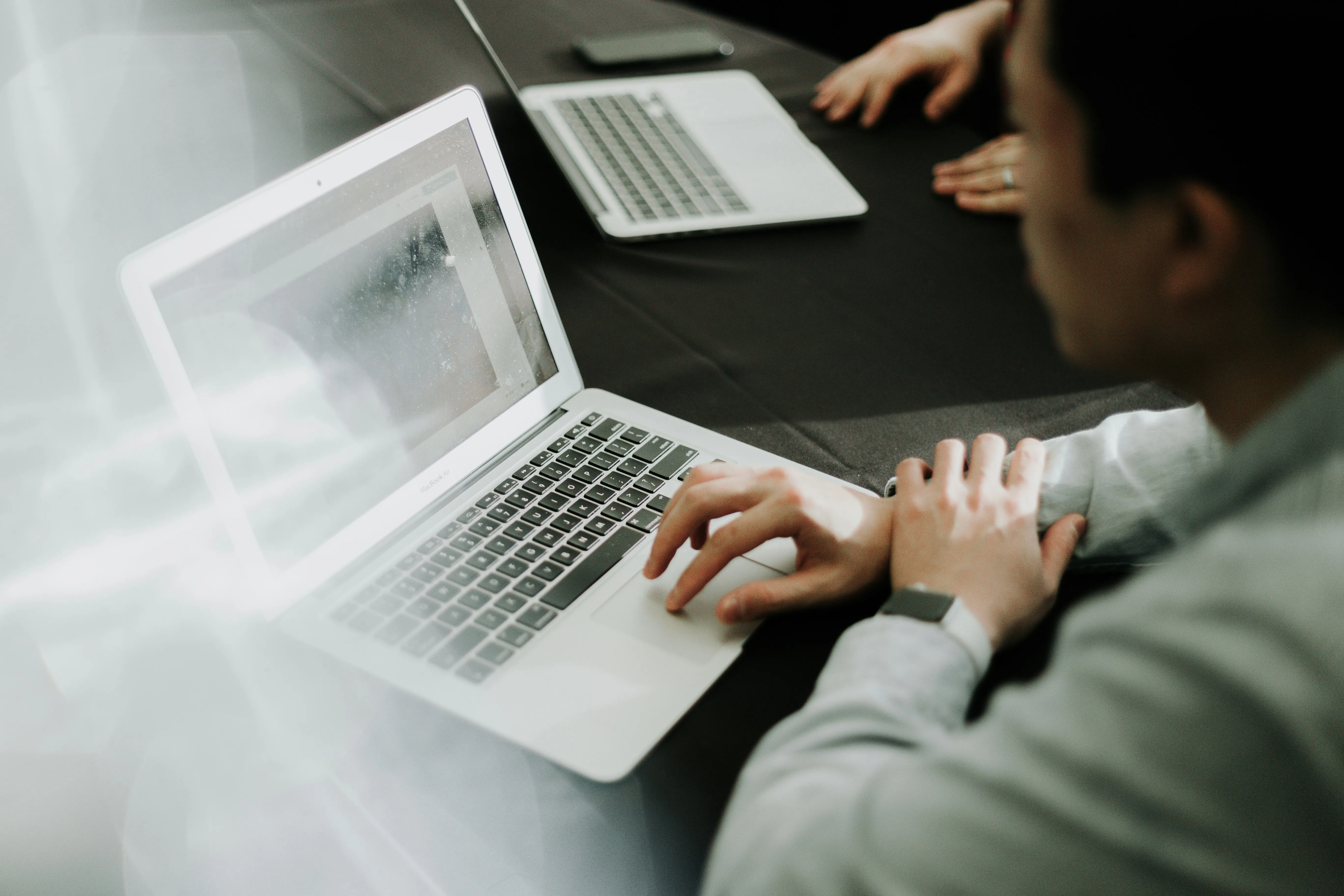 A person looking ahead with a laptop open
