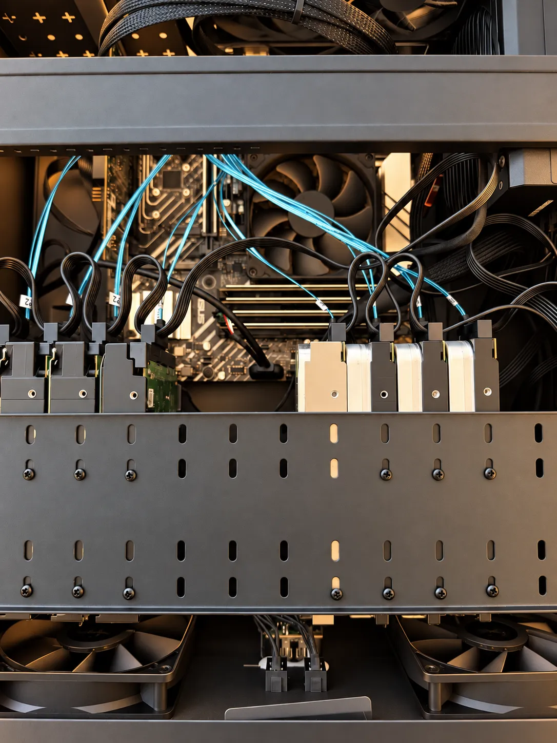 Open computer case showing a stack of hard drives in their bays